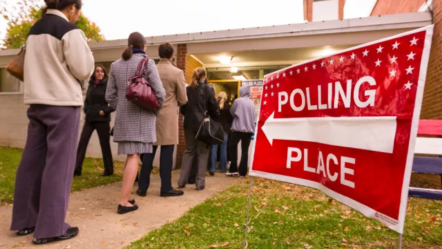 Voting polling place sign and people lined up on presidential election day 